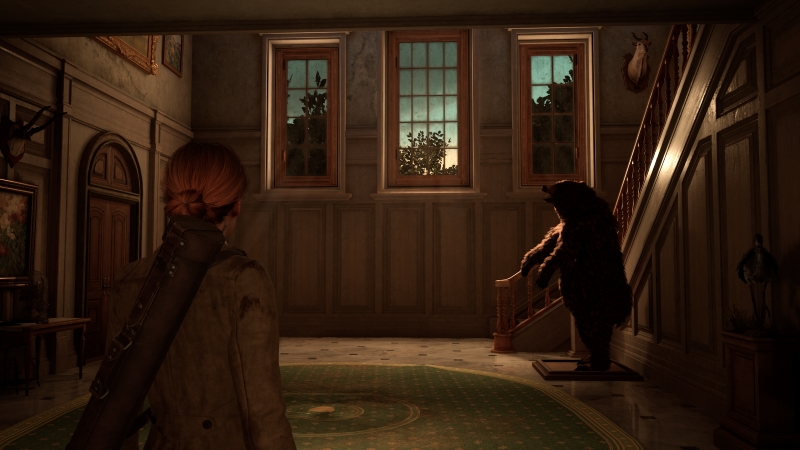 Alone In The Dark: Emily in a hallway with a stuffed bear at the bottom of a staircase.