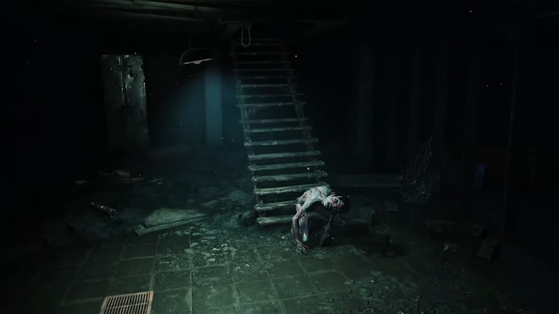 Still from a teaser showing a frail man in a dark basement.