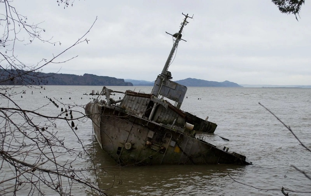 Submechanophobia: a rusty old boat sinking into water. Submechanophobia: a rusty old boat sinking into water.